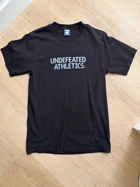 Undefeated Black Tee with Light Blue Logo